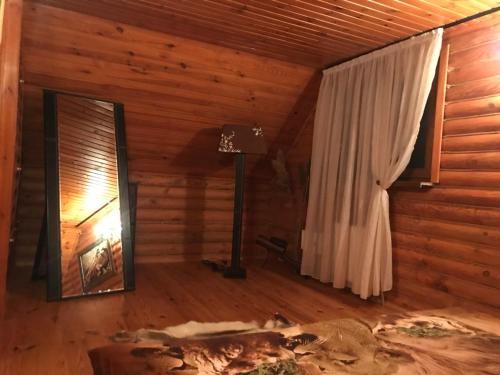 a room with a bed and a lamp and a window at Рыбацкий домик in Mayaki