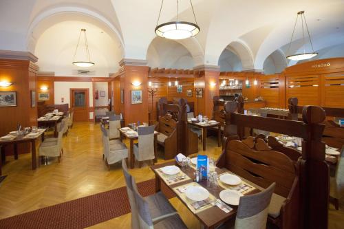 a restaurant with tables and chairs in a room at Arany Bárány Hotel in Zalaegerszeg