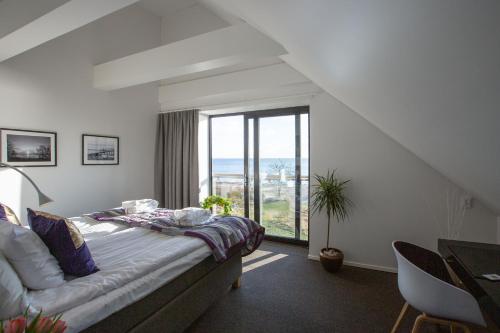 a bedroom with a bed and a large window at Smygehus Havsbad in Smygehamn