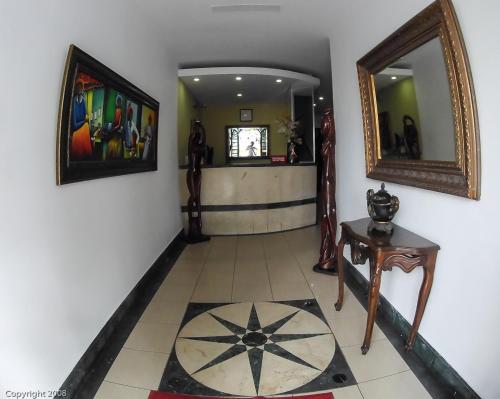 a hallway with a mirror and a tile floor at Hotel Discovery in Santo Domingo