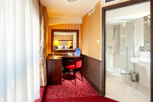 a bathroom with a desk and a bathroom with a shower at Hotel Wielopole in Krakow