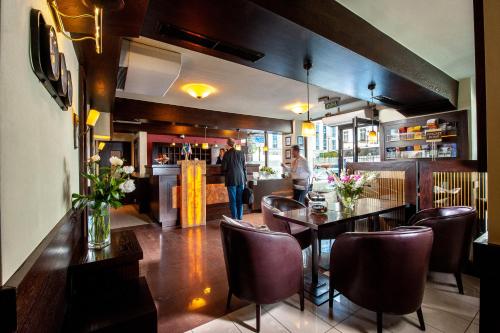 a restaurant with a table and chairs and a bar at Hotel Wielopole in Krakow