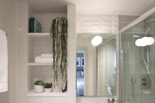 a bathroom with a shower and a glass shower stall at Inhabit Southwick Street, a Member of Design Hotels in London