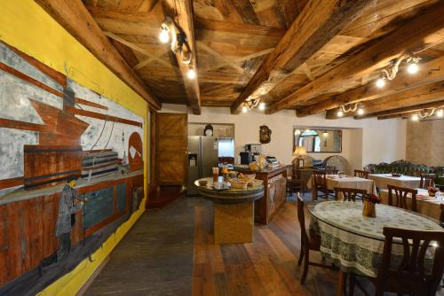 アオスタにあるVecchio Mulino Guest Houseの木製の天井、テーブルと椅子のあるレストラン