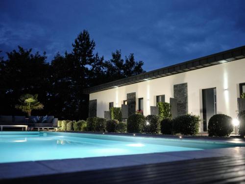 ein Schwimmbad vor einem Gebäude in der Nacht in der Unterkunft Hostellerie de la Renaissance - Teritoria in Argentan