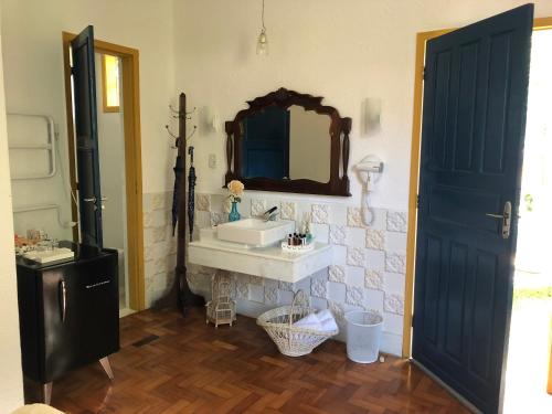 a bathroom with a sink and a mirror at Pousada Vila Brasil in Petrópolis