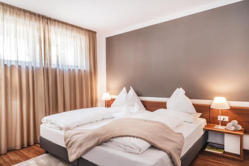 a bedroom with a large bed with white pillows at Hidalgo Suites in Postal
