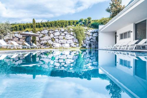 a swimming pool with chairs and a stone wall at Hidalgo Suites in Postal