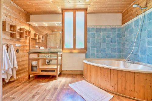 uma casa de banho com uma banheira e um lavatório em Skiers lodge St Gervais em Bionnay