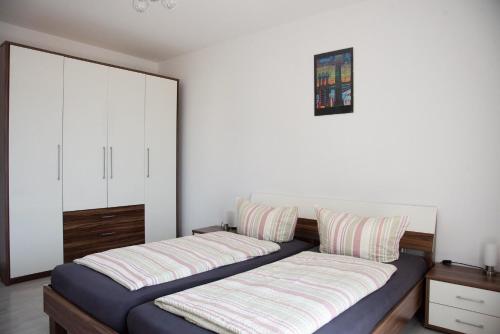 1 dormitorio con 2 camas y armario en Ferienwohnungen Richard Wurz, en Reichenau
