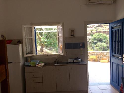 a kitchen with a sink and a window at Villa Costa Studios in Vathi, Sifnos