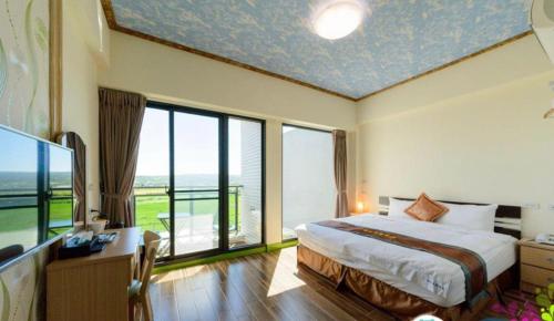 a hotel room with a bed and a large window at Yiren Hotel in Hengchun