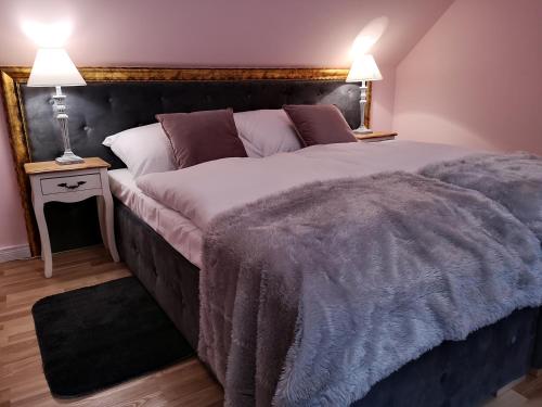 a large bed in a bedroom with two lamps at Ranczo w Dolinie Karpia - blisko "Energylandii" Zator in Spytkowice