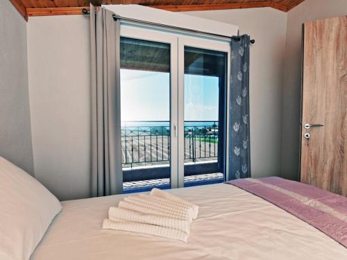 una camera con un letto e una grande finestra di Iris Sunset Luxury Apartments - Nea Potidea Halkidiki a Nea Potidaea