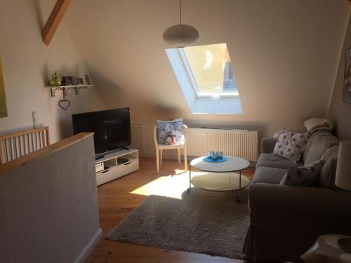 a living room with a couch and a tv at Ferienhaus Schlupfwinkel in Bad Neuenahr-Ahrweiler