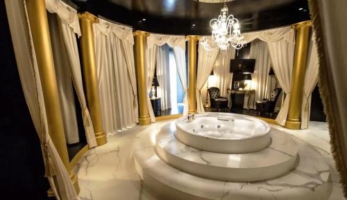 a bathroom with a large tub in a room with windows at Emotional Grand Motel in Fontaneto dʼAgogna