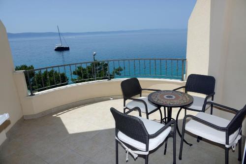 a balcony with a table and chairs and the ocean at Apartments Nevenka i Josko in Tučepi