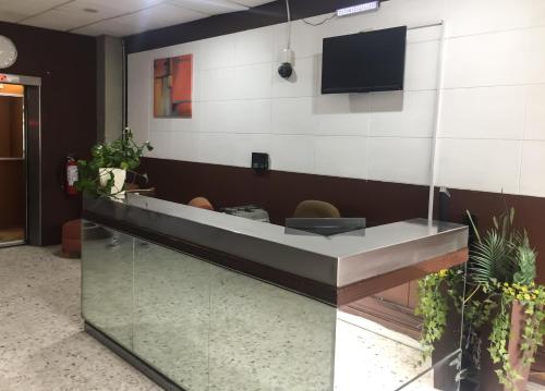 a lobby with a reception desk with a tv on the wall at Hotel Trevi in Salamanca