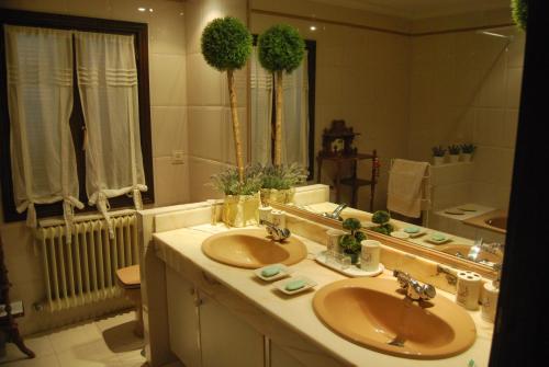 a bathroom with two sinks and a large mirror at El Campillo in Pelabravo