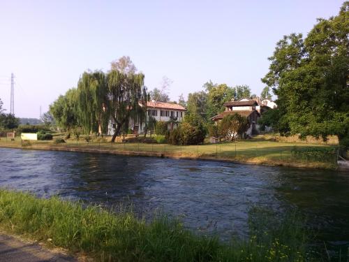 a river with a house in the background at Agriturismo Cascina Poscallone in Abbiategrasso