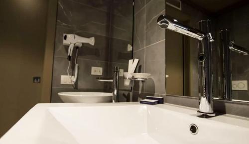 a bathroom sink with a faucet and a mirror at Emotional Grand Motel in Fontaneto dʼAgogna