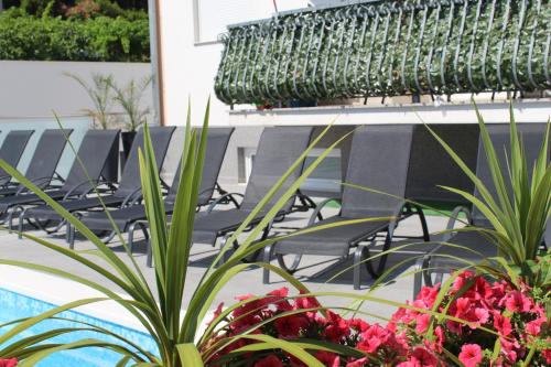 a group of chairs and flowers next to a pool at Luxury Apartment Antoni in Podstrana