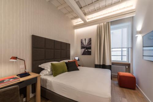 a bedroom with a bed and a desk and a window at Laurina 33 in Rome