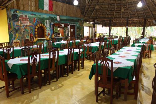 eine Gruppe von Tischen und Stühlen mit grünem Tischtuch in der Unterkunft Hotel Nueva Alianza in Frontera Corozal