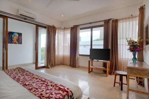Televisyen dan/atau pusat hiburan di Keramas Beachfront Villa by Sanga Sanga Hospitality