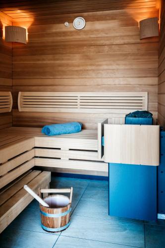 a sauna with a bench and a tub in a room at Logis Hôtel Restaurant Au Lion Rouge in Bartenheim