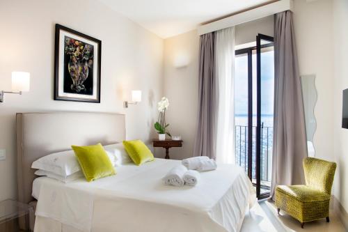 a bedroom with a large white bed with yellow pillows at I Bastioni San Domenico - Boutique Hotel in Gallipoli