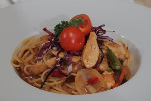 a bowl of pasta with shrimp and a tomato at Hotel Jelena in Banja Luka