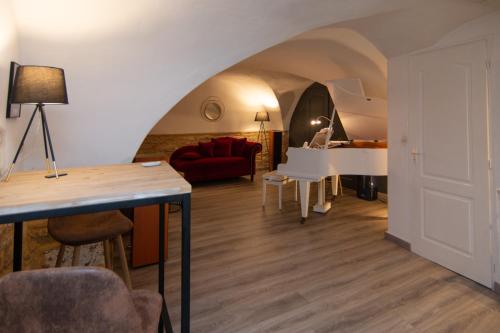 un salon avec une table et un canapé rouge dans l'établissement La Vermeillade Maxi-Jacuzzi & Terrasse privés à 7 mn de Sommières, à Congéniès