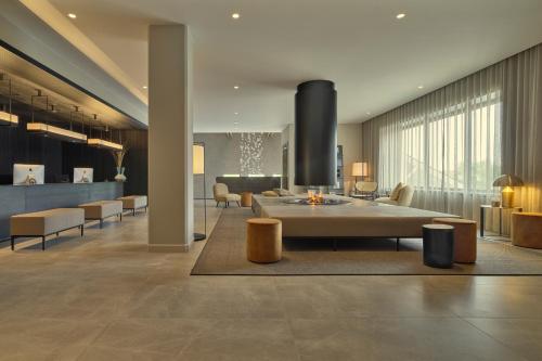 a lobby with a couch and a table and chairs at Hotel de Blanke Top in Cadzand-Bad