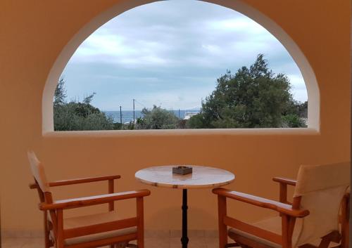 una ventana arqueada con mesa y 2 sillas en Dagris Villa Studios en Kamari