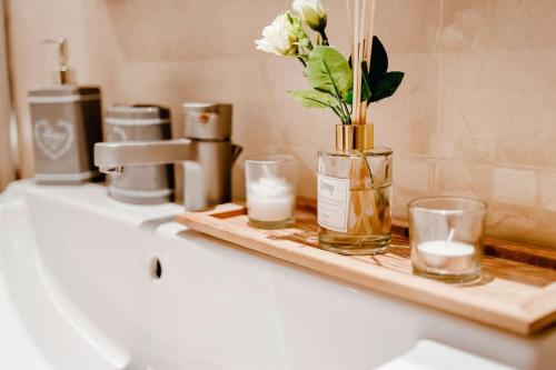 a bathroom counter with candles and a vase with flowers at Cotobro Rental House in Almuñécar