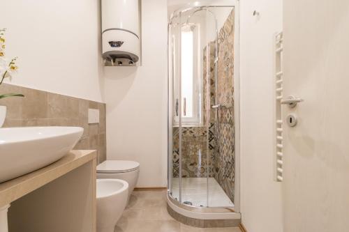 uma casa de banho com um chuveiro, um WC e um lavatório. em Pregiata camera con bagno privato - Blu di Prussia em Trieste