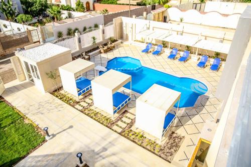 een uitzicht over een zwembad met stoelen en tafels bij Serenity Home Hurghada in Hurghada