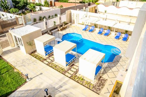 Serenity Home Hurghada في الغردقة: اطلالة علوية على مسبح مع كراسي وطاولات