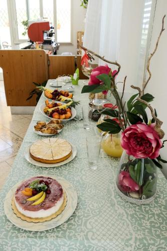 a table with plates of food and a vase with flowers at Hotel Porto Badisco in Porto Badisco