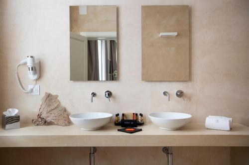 a white sink sitting under a mirror in a bathroom at I Bastioni San Domenico in Gallipoli
