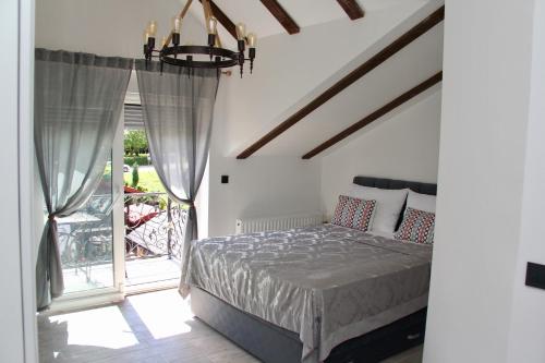 a bedroom with a bed and a balcony at Villa Waterfalls Plitvice in Rakovica