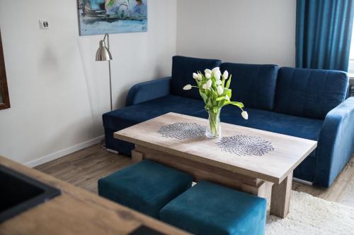 a living room with a vase of flowers on a table at Apartamenty Ciche Wzgórze Zakopane in Zakopane