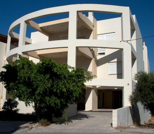 un grande edificio bianco con un albero di fronte di Mom's Cozy Corner a Heraklion