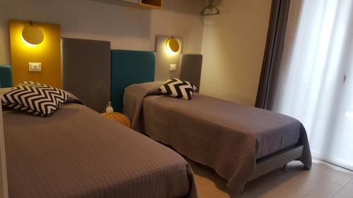 a hotel room with two beds and a window at Dolce Vita in Zafferana Etnea