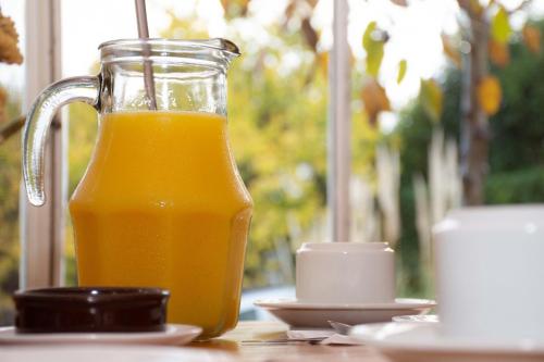 a glass jug of orange juice sitting on a table at Hostería La Viña in La Cumbre