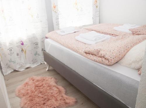 a bedroom with a bed with a pink rug at Bistrik Rose Apartment in Sarajevo