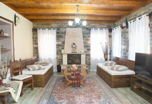 a living room with two beds and a fireplace at To Archontiko tis Nikis in Ioannina