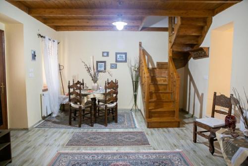 イオアニナにあるTo Archontiko tis Nikisのテーブルと椅子、階段が備わる客室です。