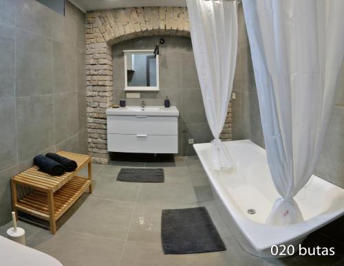 y baño con bañera y lavamanos. en Luxurious apartment en Vilna